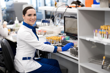 Cheerful female scientist working in modern science laboratory