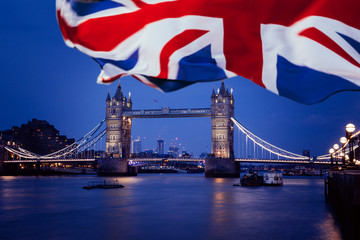 Fototapeta na wymiar Tower bridge by night and the UK flag, London.