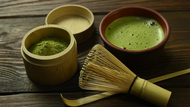 matcha tea with a cup stands on a wooden table