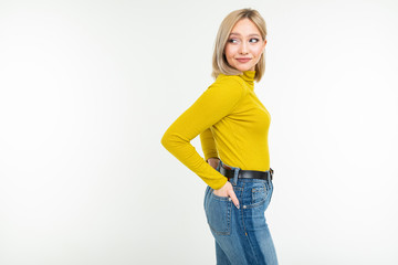 Obraz premium stylish girl in a lemon turtleneck and jeans posing on a white background with copy space