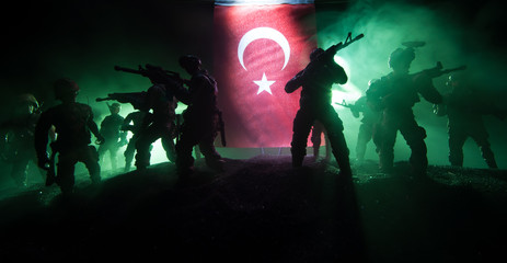 Silhouette of soldier with rifle against a turkish flag. Selective focus