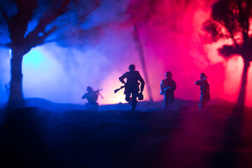 War Concept. Military silhouettes fighting scene on war fog sky background, World War Soldiers Silhouette Below Cloudy Skyline At night.