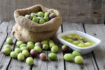 Olive sack and olive oil bowl on wooden background