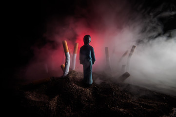 Obraz premium Ashtray and butts cigarettes on dark background. Selective focus