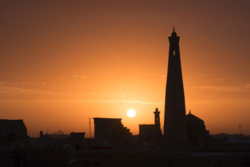 Sunrise view at Itchan Kala (old or inner town) and Islam Khoja Minaret, one of the most popular touristic attraction in the city. Khiva, Uzbekistan, Central Asia.