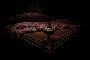 Lamp of wishes concept. Antique Aladdin arabian nights genie style oil lamp with soft light white...