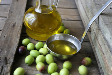 olives and olive oil on wooden background