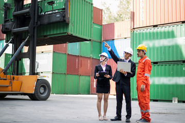 Male and Female Industrial Engineers Talk with Factory Worker while Using Laptop. They Work at the Heavy Industry Manufacturing Facility.