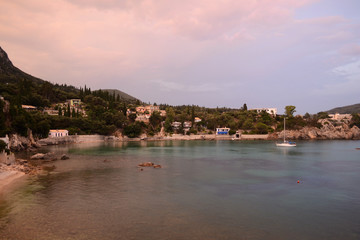 Ship in Paleokastritsa bay in sunset - Platakia Beach