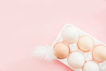 Chicken egg in egg container on pink background top view, flat lay