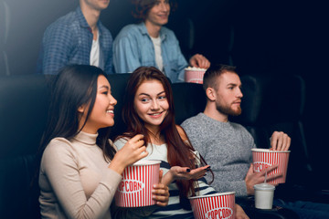 Fototapeta premium Happy friends having fun time while watching movie in cinema