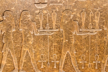 Ancient egyptian paintings and hieroglyphs carved on the stone wall