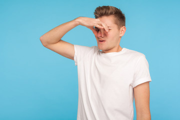 Naklejka premium Bad breath. Portrait of displeased man in casual white t-shirt closing eyes and nose in disgust, avoiding unpleasant smell of farting, stinky aroma. indoor studio shot isolated on blue background