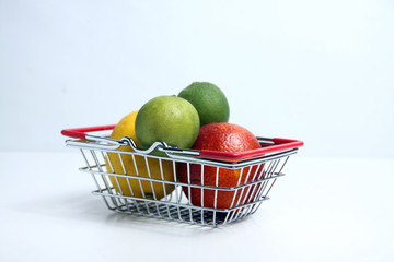citrus fruits in a shopping basket isolated on white background
