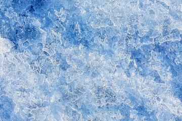 Texture of ice on the frozen lake. Blue color background.