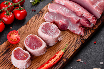 Fresh pieces pork ready to cook on a dark background in the kitchen