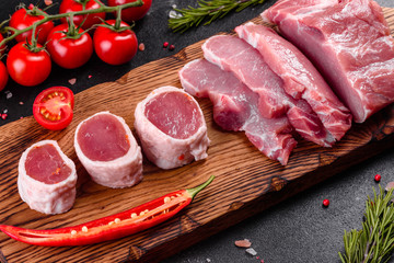 Fresh pieces pork ready to cook on a dark background in the kitchen