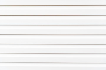 White construction vinyl siding panels. House covered with plastic vinyl siding. Vinyl siding wall surface with horizontal lines