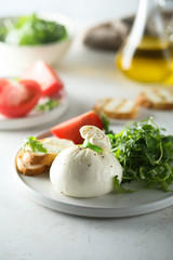 Italian cheese salad with tomatoes and arugula