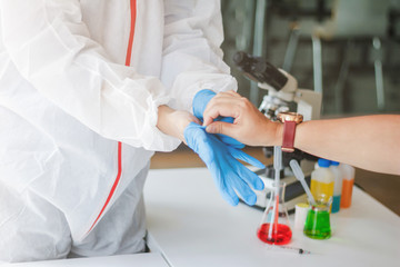 Medical scientists are wearing coronavirus protective clothing and rubber gloves before entering the lab for examination of coronavirus covid-19 and research for a vaccine against coronavirus covid19