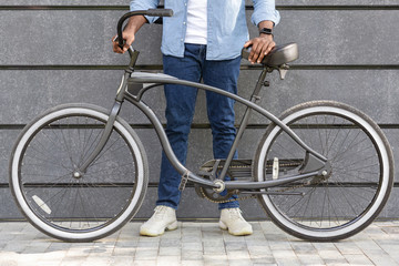 Fototapeta na wymiar Unrecognizable Afro Man Holding Bicycle With Stylish Design