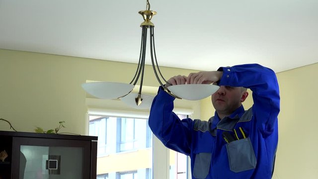 man worker change economical light bulb in client apartment. 4K