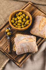 Fototapeta na wymiar Fresh italian ciabatta on a wooden board with olives
