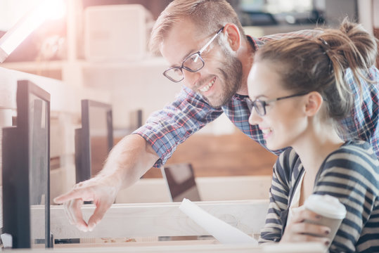 Young Casual Business Couple Using Computer In The Office. Two Colleagues Working Together On An Innovative Product Design In A Creative Studio. Co Working, Creative Manager Showing New Startup Idea.