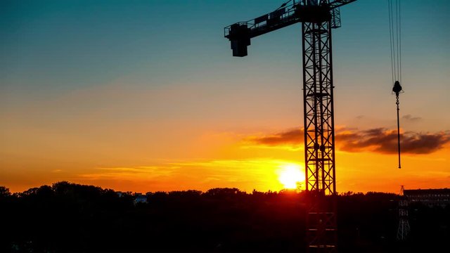 Unusually beautiful sunset on the background of a crane, timelapse