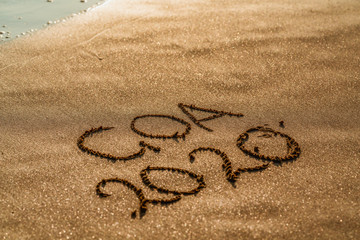 foamy sea water and Inscription Goa on the sandy beach