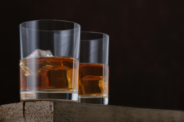 Two glasses of whiskey on wooden table