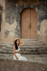 Beautiful woman of eastern appearance among ancient street stone architecture.