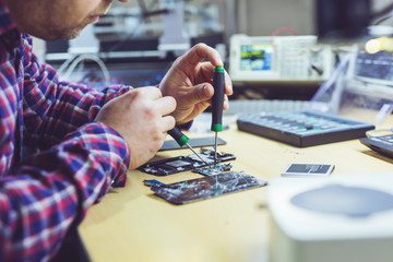 Professional repairman repairing computer in workshop.