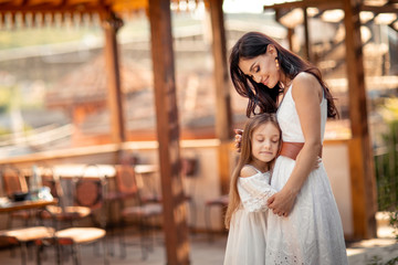 Young beautiful mother of eastern appearance walks with her daughter on the ancient streets of the Mediterranean city.