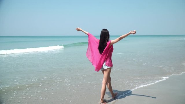 Young beautiful Asian woman girl relaxing and walking on the beach seaside in summer sunny day. Attractive sexy woman having fun and feel freedom in vacation. Lifestyles travel trip in summer concept.