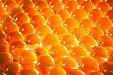 Orange hydrogel balls. Bright round gel. Caviar. Transparent water texture. Fresh colorful background. Macro