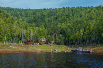 Beautiful landscape. Zeya reservoir, Amur region. View from the sea to the wooden buildings of the Zeya nature reserve cordon against the backdrop of green forests and hills.
