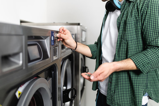 Young man doing his weekly washing in a laundromat.
