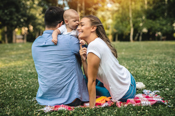 Happy young family enjoying together in park.