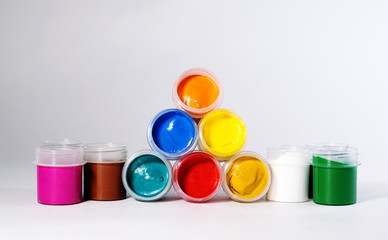 Multi-colored gouache in plastic jars on a white background to create beautiful paintings