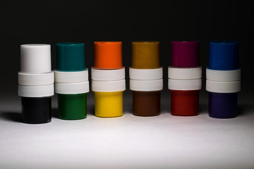 Multi-colored gouache in plastic jars on a white background to create beautiful paintings