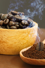 Roasted coffee beans ground on a wooden spoon.