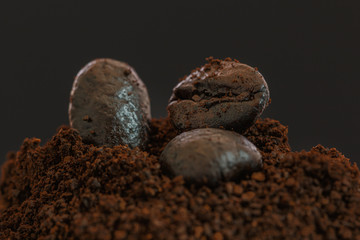 Coffee beans roasted dark and mashed on a  with a dark background