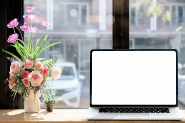 Laptop with blank on wooden table in cafe. Blank screen for graphic design.