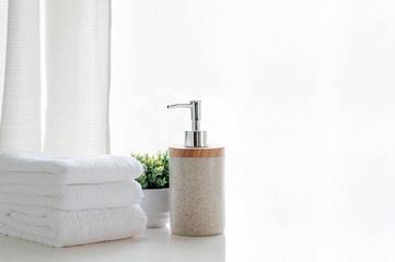 Bath towels on wite table in bathroom.