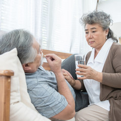 elder man take pills while elder woman take care.