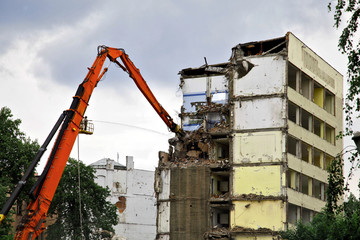 Fototapeta na wymiar crane lift works on demolition of brutal reinforced concrete plate build biulding