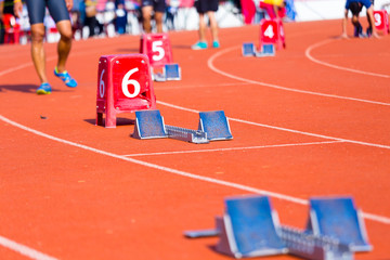Runner using a starting block to start his run on race track.