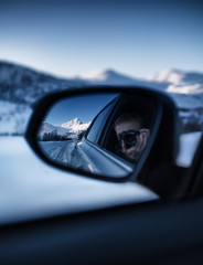 Photography in the rearview mirror. Travel by car in the mountains. Landscape in winter. Norway -...