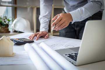 The engineer designed the house structure in the blueprint and working in the architect's room,...